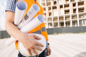 Engenheiro civil segurando rolos com os mapas de construção